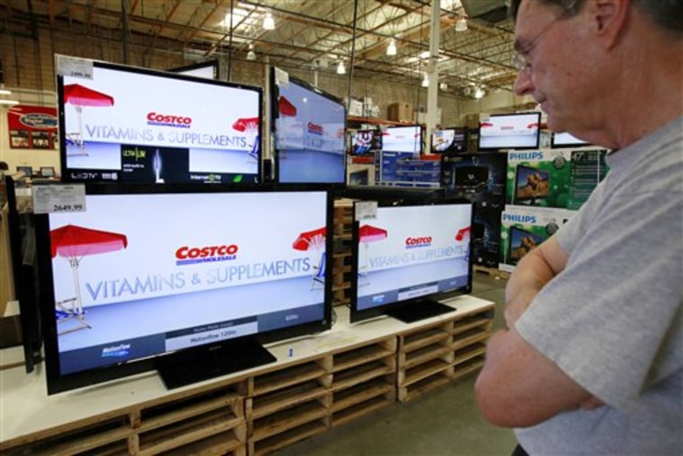 In this May 4, 2010 photo, a customer looks at wide screen television sets at a Costco store in Mountain View, Calif. Early reports from retailers show that Americans took a a breather from their March shopping spree in April, partly because Easter came earlier.